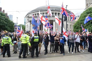 Far-right Britain First party supporters wave Union Flags and St George Cross flags during march in 2025
